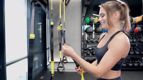Beautiful Trainer Preparing Trx for Workout