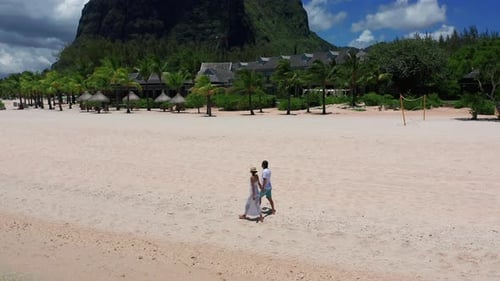 Young Couple Walking and Holding Hands at the Beach