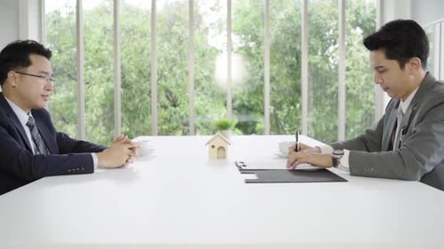 Men Signing Real Estate Contract in Bright Office