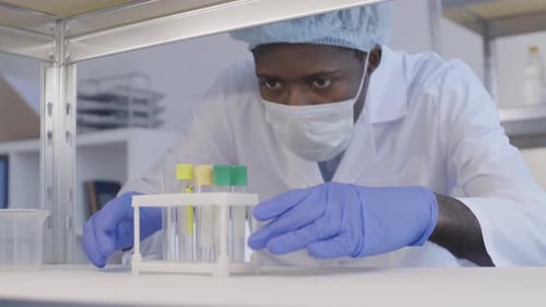 Un scientifique africain portant un uniforme de protection en laboratoire