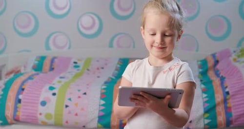 Girl Enjoys Tablet Technology in Bedroom