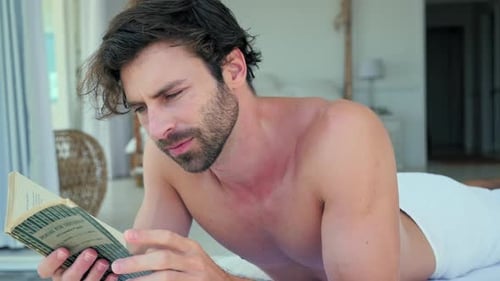 Man Reading Book While Relaxing Indoors