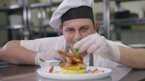 Chef Plates Seafood Dish with Green Garnish