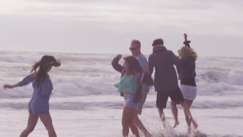 Group of friends at beach running together
