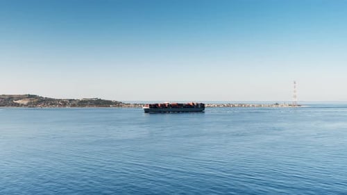Container Ship Sails in the Calm Sea in the Distance