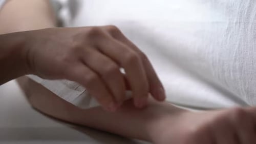 Woman Tearing Wax Plaster From Hand of Client, Removal of Unwanted Hair, Beauty