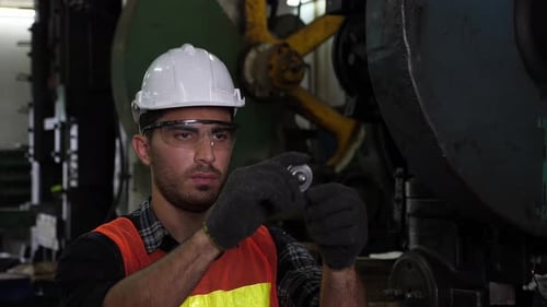 Un ingeniero caucásico masculino profesional comprueba la calidad de la producción