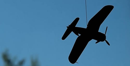 Rotating Airplane Silhouette against Blue Sky