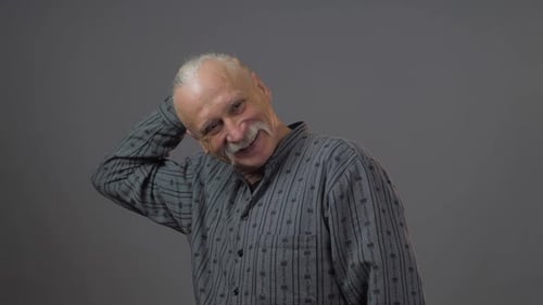 Cheerful Grandfather with Long Grey Mustache Scratches Head