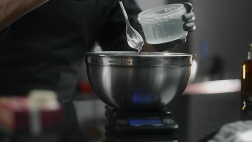 Der Küchenchef nimmt etwas viskose Glukose und gibt sie zum Schmelzen und Kochen eines süßen Desserts in die Pfanne