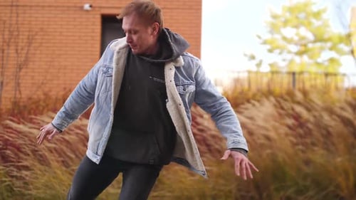 A Man Dancing Hiphop Against the Background of a Kerpic Building