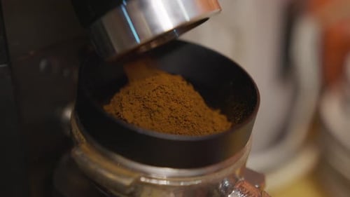 Ground Coffee Pouring from Coffee Grinder Close Up