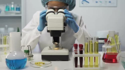Scientist Uses Microscope in Research Laboratory