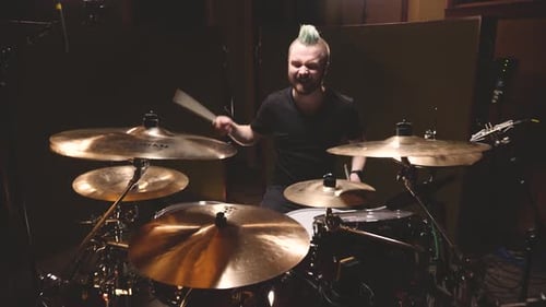 Drummer performing in a studio setting.