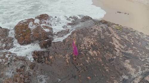 Woman Standing On The Rocky Shore