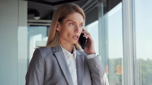 Concentrated Businesswoman Talking Mobile Phone in Office