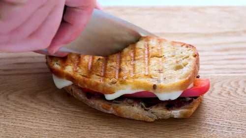 Cutting a Toasted Sandwich in Half on Wood