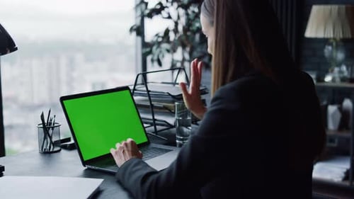 Confident Businesswoman Having Video Call at Laptop with Green Screen in Office
