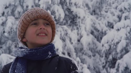 Happy child looking around on a snowy winter day.