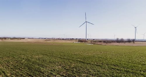 Wind turbines in the rape field - aerial footage. Aerial flight at Sunset over windmill WindPark gre