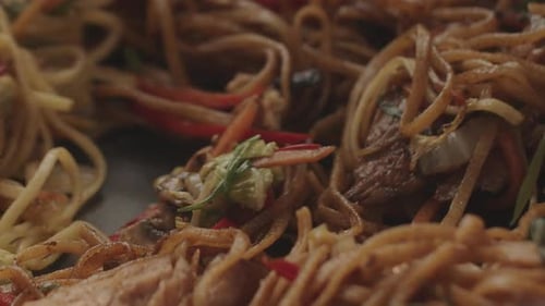 Close-up Noodles with Vegetables Being Stirred with Tongs