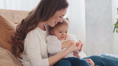 Kaukasische junge Mutter mit kleinem Mädchen, das sich umarmt, verbringt Zeit miteinander zu Hause Loving Mom