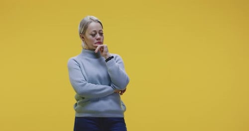 Thoughtful Woman Thinking in Front of Yellow Background