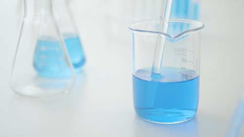 Clear Liquid Transferred to Beaker with Blue Liquid