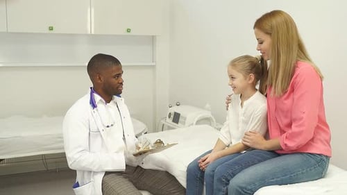Doctor Consults With Child and Mother in Office