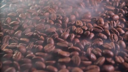 Ароматные кофейные зерна в процессе обжарки с присутствием небольшого количества дыма