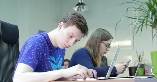 Three Young Business People Using Computer in the Office. Two Decorator's Colleagues Working