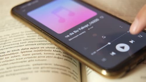 Smartphone Plays Music App on an Open Book