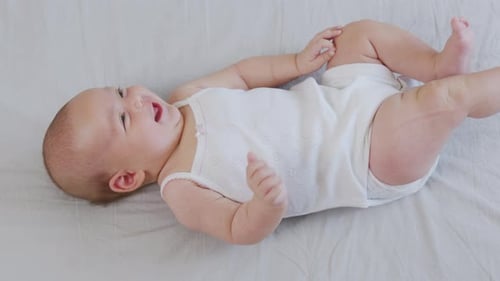 Happy Infant Lying on Back on Gray Blanket