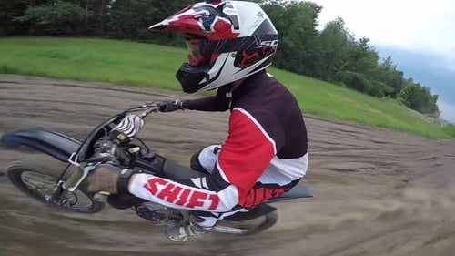 Dirt Biker Riding Along a Rural Dirt Path