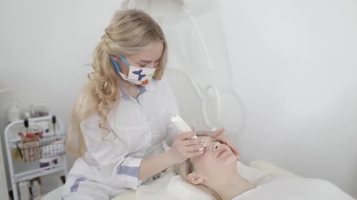 Woman Receiving Facial Treatment in Clinic