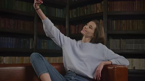 Young Woman Taking Selfie on Couch Indoors