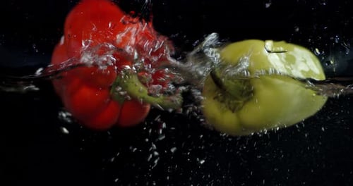 Colorful Bell Peppers Dropping Into Water on Black