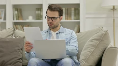 Man Working on Laptop at Home on Couch