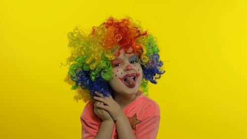 Happy Child Clown Posing Playfully Against Yellow