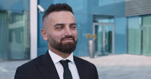 Confident Businessman Walking at Business Area Between Office Buildings