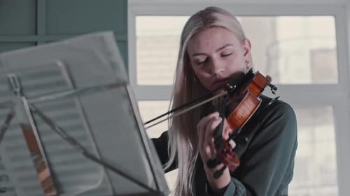 Woman Plays Violin With Sheet Music Indoors