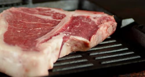 Steak T-Bone rotiertes Rindfleisch in einer Bratpfanne dreht sich langsam