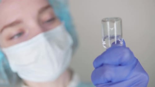 Medical Professional Examining Vial in Close-up Shot