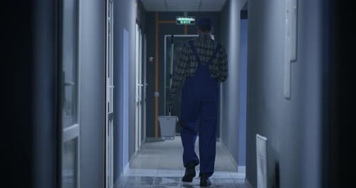 Janitor Cleaning a Corridor