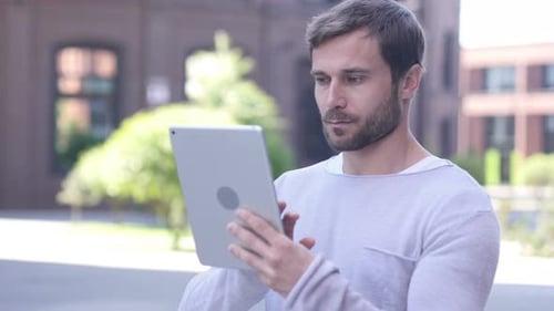 Man Using Tablet Outdoors in Urban Environment