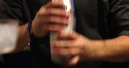 Bartender Shakes Cocktail Shaker at Night
