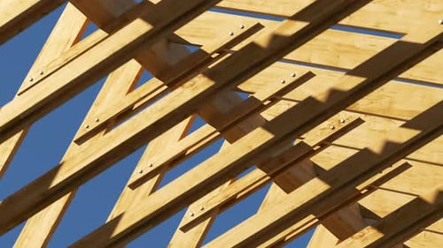 Toma en bucle con la cámara moviéndose a lo largo de la armadura de madera sin terminar del techo.