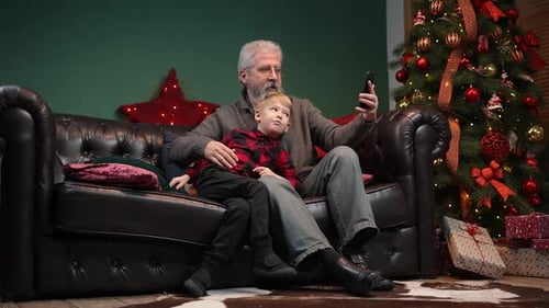 Grandfather and Child Waving During Christmas Video Call