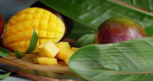 Cut Into Slices of Ripe Mango on Cutting Board Rotates Slowly.
