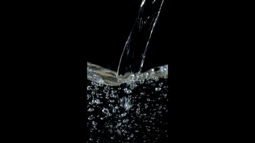 Pouring Clear Refreshing Water Forming Bubbles